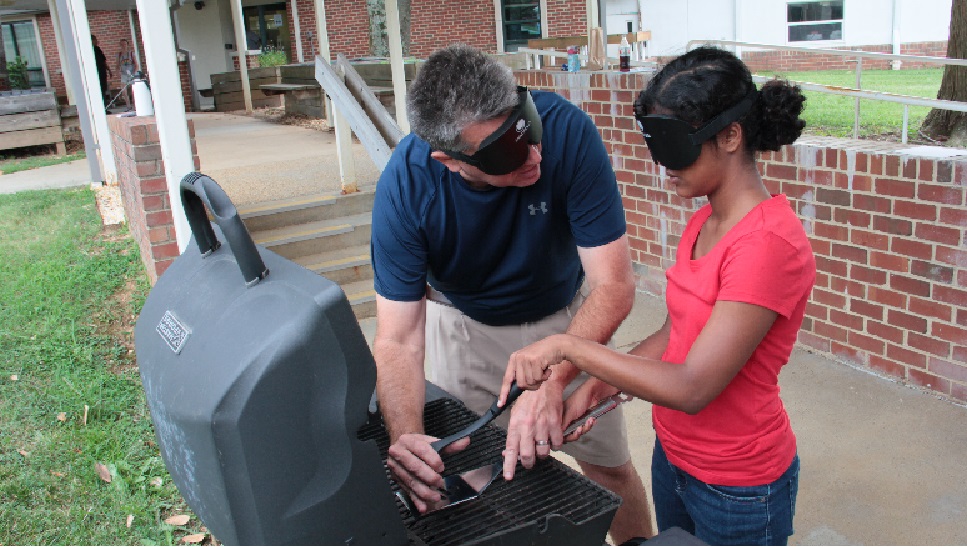 Former LIFE student explores an open grill with instructor